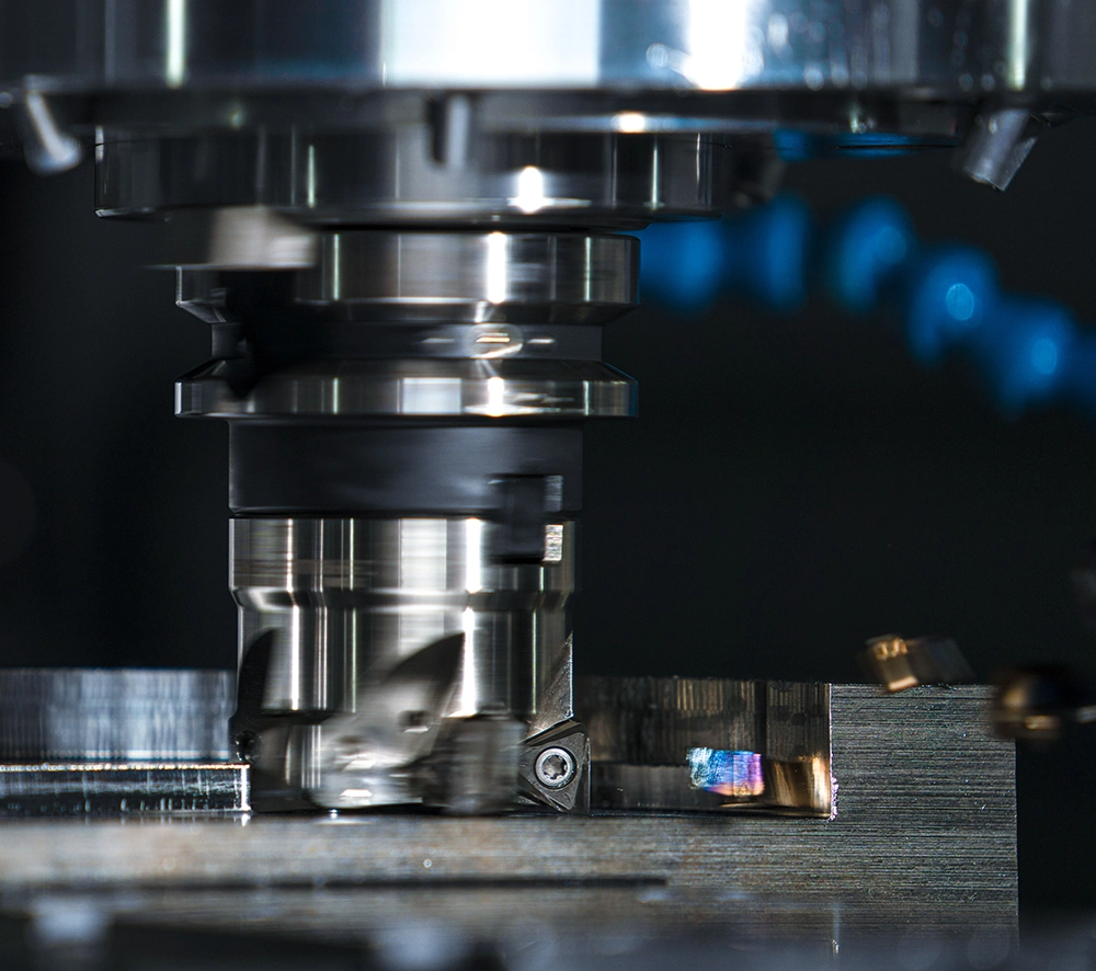 CNC milling machine cutting a metal component with coolant